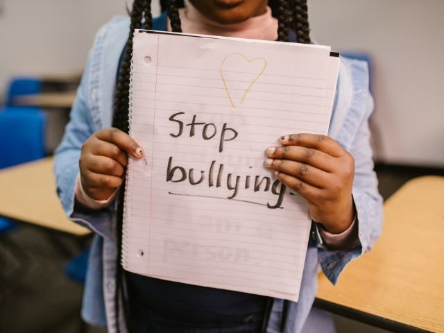 Student holding piece of paper that says stop bullying