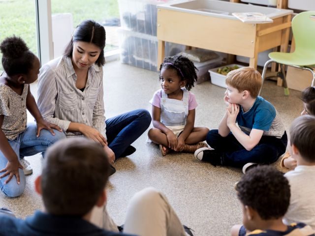 Teacher sitting in circle with diverse set of students